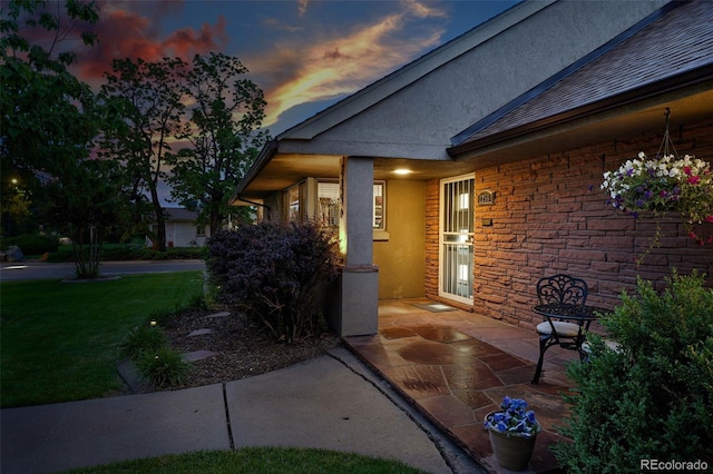 2250 N Monaco Pkwy, Denver, CO 80207 - exterior entry at dusk featuring stucco siding and a yard