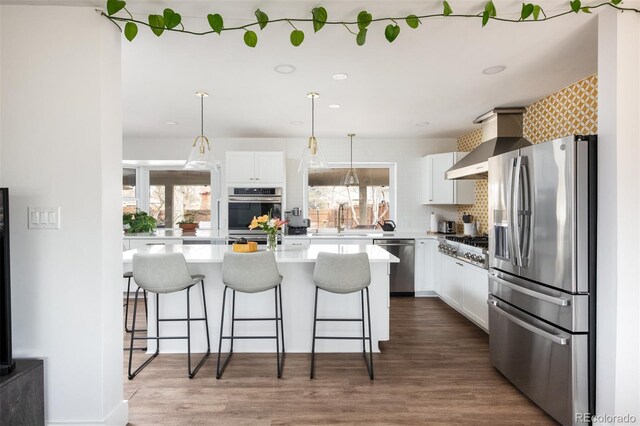 2250 N Monaco Pkwy, Denver, CO 80207 - kitchen featuring appliances with stainless steel finishes, white cabinets, a breakfast bar area, light countertops, and dark wood-style flooring
