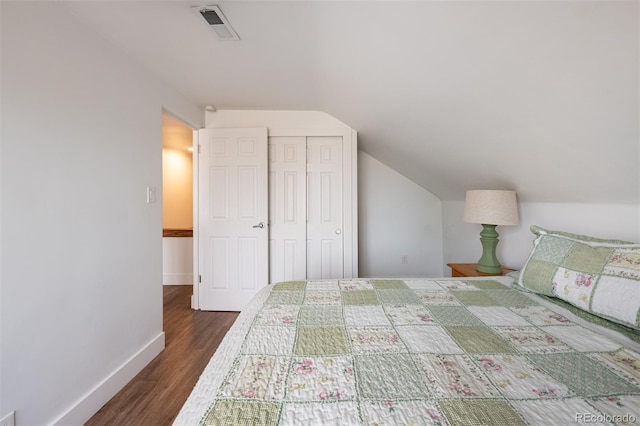 2250 N Monaco Pkwy, Denver, CO 80207 - bedroom with dark wood-style floors, lofted ceiling, and a closet