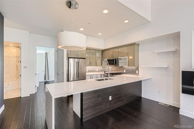 3030 N Wilson Ct Unit 3, Denver, CO 80205 - kitchen with stainless steel appliances, a peninsula, light countertops, tasteful backsplash, and dark wood-style floors
