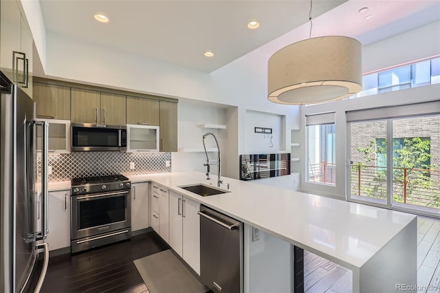 3030 N Wilson Ct Unit 3, Denver, CO 80205 - kitchen featuring stainless steel appliances, a peninsula, light countertops, decorative backsplash, and recessed lighting