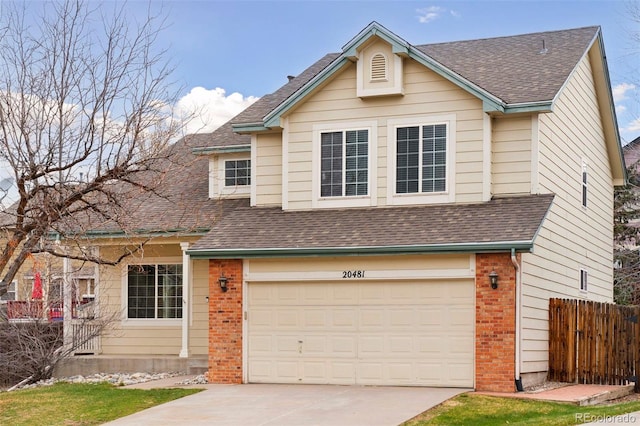 view of front facade with brick siding, driveway, a shingled roof, and a garage