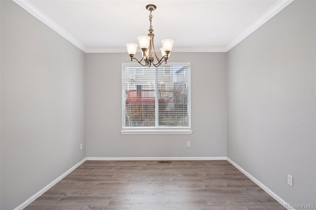 unfurnished room with baseboards, wood finished floors, a notable chandelier, and ornamental molding