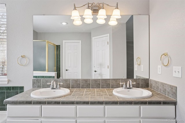 bathroom featuring a sink, a shower stall, and double vanity