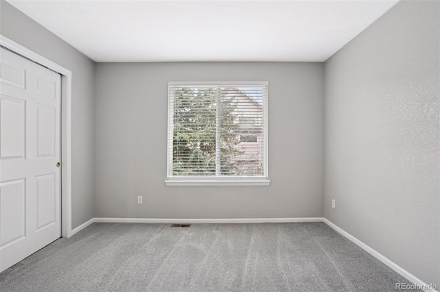 unfurnished bedroom with carpet, visible vents, and baseboards