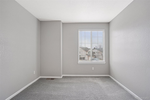 spare room with baseboards and carpet flooring