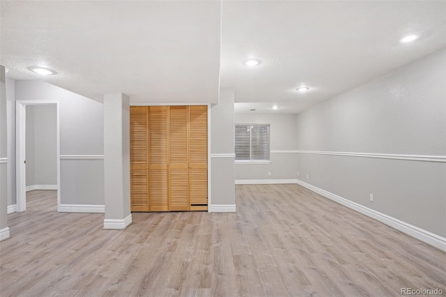 basement featuring light wood finished floors, baseboards, and recessed lighting