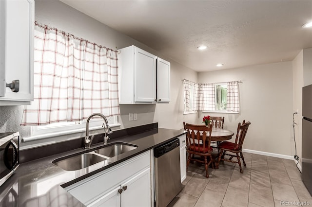 5001 W Nevada Pl, Denver, CO 80219 - kitchen featuring stainless steel dishwasher, dark countertops, white cabinetry, light tile patterned flooring, and recessed lighting