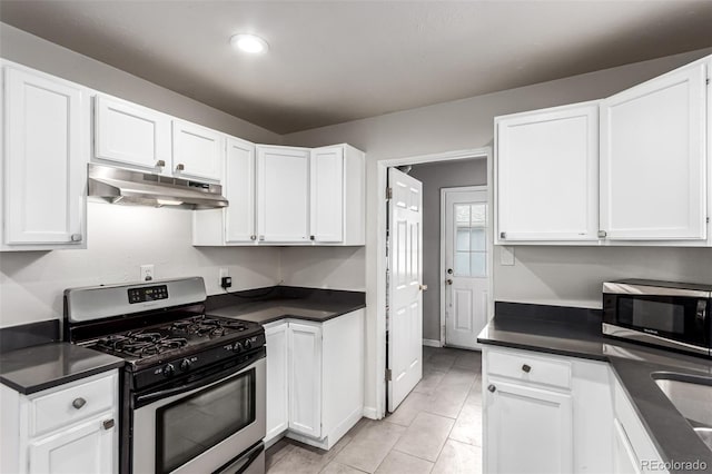 5001 W Nevada Pl, Denver, CO 80219 - kitchen with under cabinet range hood, appliances with stainless steel finishes, dark countertops, and white cabinetry