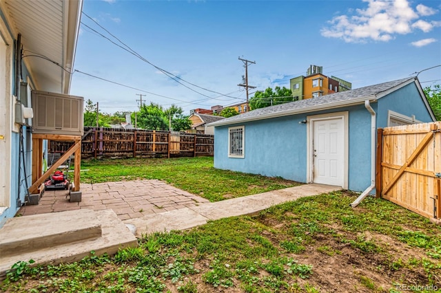 5001 W Nevada Pl, Denver, CO 80219 - fenced backyard featuring a patio, an outdoor structure, and a gate