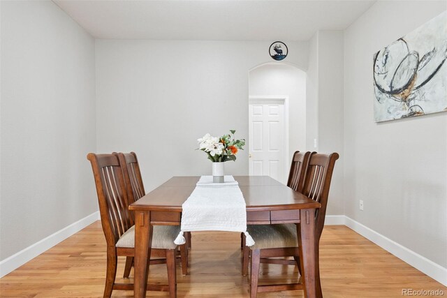 12942 Leyden St, Thornton, CO 80602 - dining space featuring arched walkways, light wood-type flooring, and baseboards