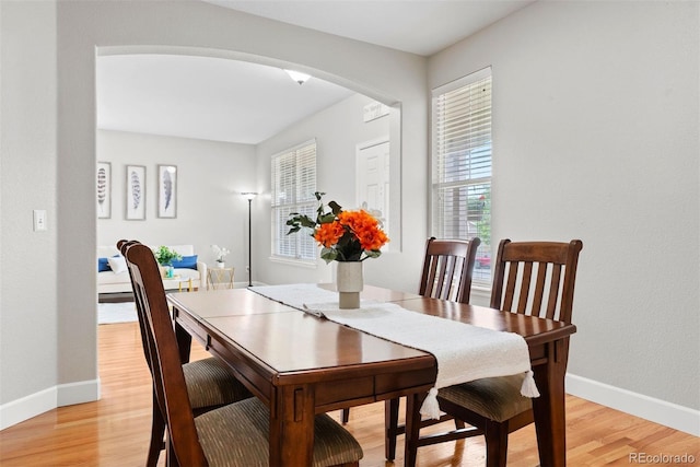 12942 Leyden St, Thornton, CO 80602 - dining area featuring light wood-type flooring, arched walkways, and baseboards