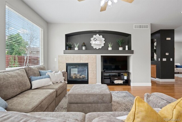 12942 Leyden St, Thornton, CO 80602 - living area featuring wood finished floors, a ceiling fan, a tile fireplace, and baseboards