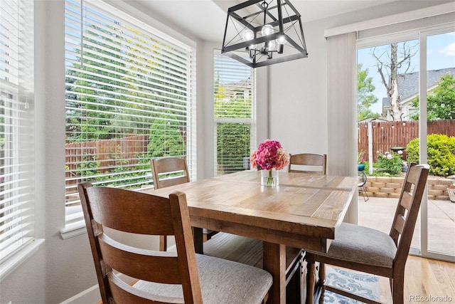 12942 Leyden St, Thornton, CO 80602 - dining area with a chandelier, light wood-type flooring, and baseboards