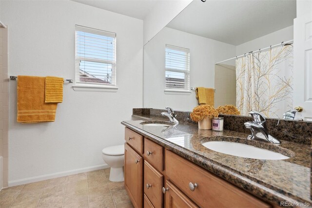 12942 Leyden St, Thornton, CO 80602 - full bathroom featuring toilet, double vanity, baseboards, curtained shower, and tile patterned floors