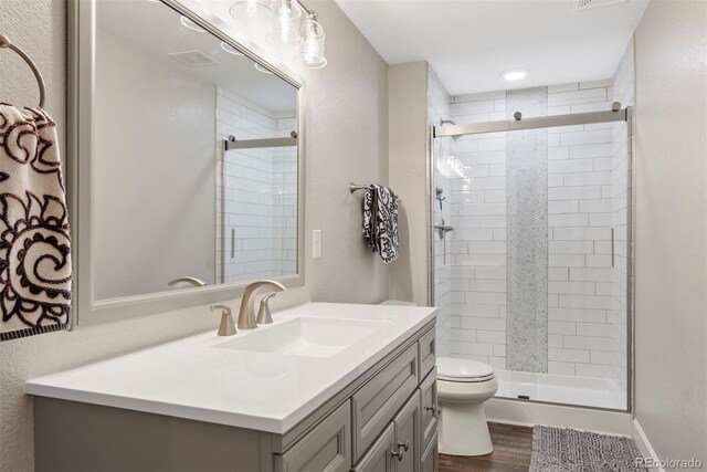 12942 Leyden St, Thornton, CO 80602 - full bathroom featuring toilet, vanity, wood finished floors, and a stall shower