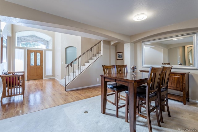 dining space featuring lofted ceiling and light hardwood / wood-style flooring