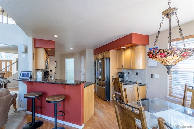 kitchen featuring stainless steel refrigerator, plenty of natural light, and light hardwood / wood-style flooring