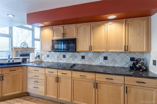 kitchen featuring black appliances, plenty of natural light, sink, and light hardwood / wood-style flooring