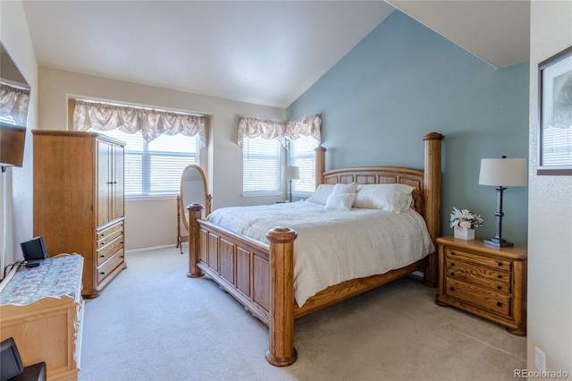 bedroom featuring light colored carpet and lofted ceiling