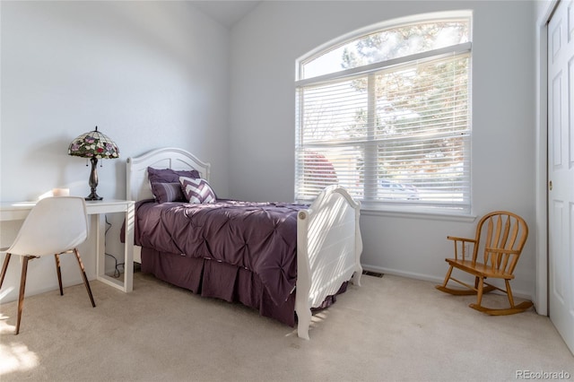 carpeted bedroom with vaulted ceiling and multiple windows