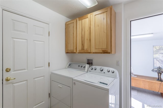 washroom with washer and clothes dryer and cabinets