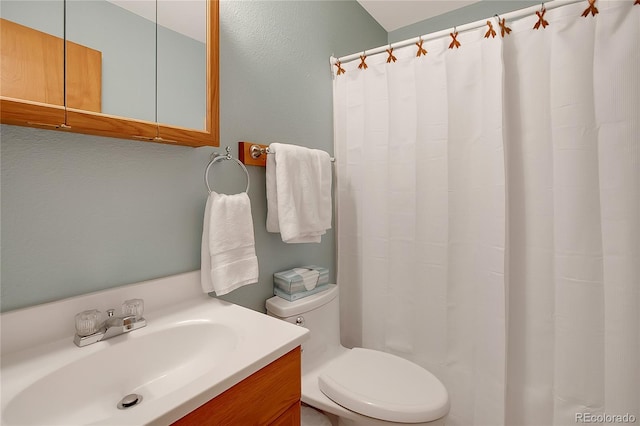 bathroom with curtained shower, toilet, and vanity