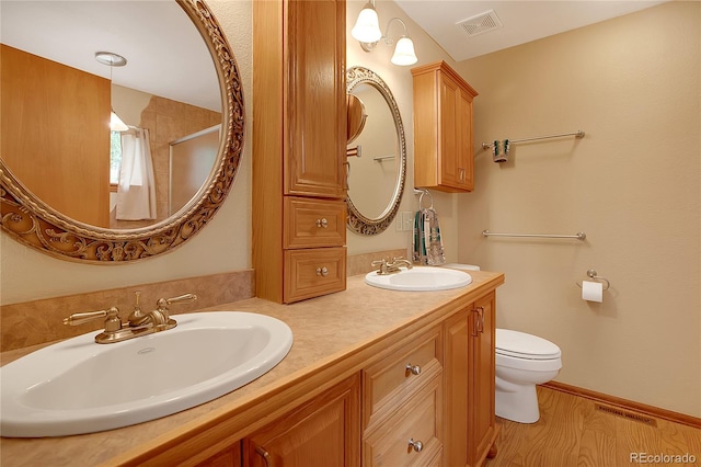 bathroom featuring vanity, toilet, and hardwood / wood-style flooring