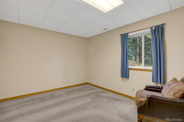 carpeted spare room featuring a drop ceiling