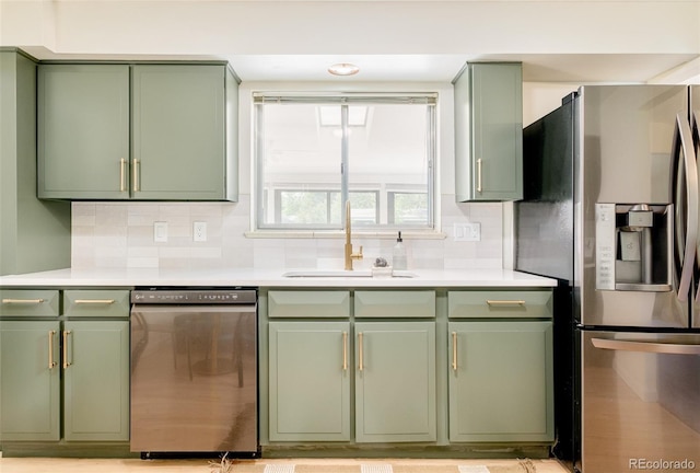 85 S Flower St, Lakewood, CO 80226 - kitchen with green cabinets, stainless steel appliances, a sink, backsplash, and light countertops