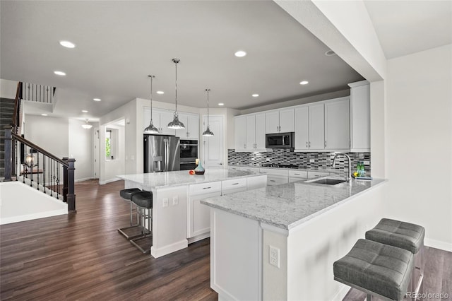 7166 S Vandriver Way, Aurora, CO 80016 - kitchen with appliances with stainless steel finishes, a kitchen breakfast bar, recessed lighting, backsplash, and white cabinets