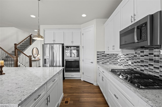 7166 S Vandriver Way, Aurora, CO 80016 - kitchen with stainless steel appliances, decorative backsplash, white cabinetry, light stone countertops, and decorative light fixtures