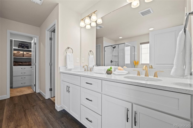 7166 S Vandriver Way, Aurora, CO 80016 - bathroom featuring double vanity, a stall shower, a spacious closet, wood finished floors, and recessed lighting