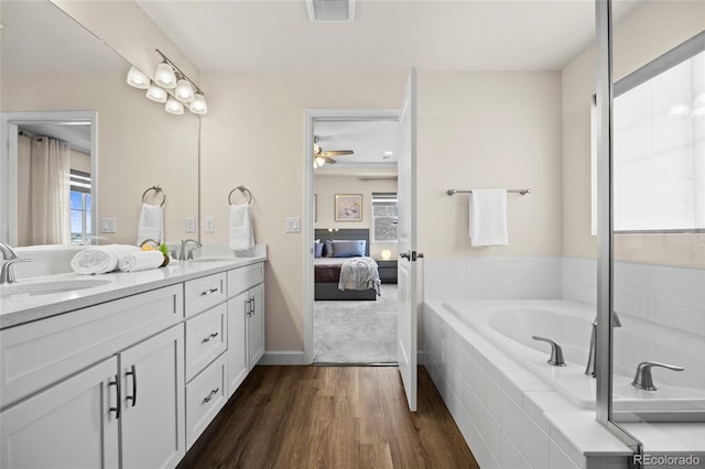 7166 S Vandriver Way, Aurora, CO 80016 - bathroom featuring double vanity, wood finished floors, ensuite bathroom, a garden tub, and ceiling fan