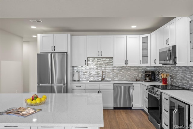 7166 S Vandriver Way, Aurora, CO 80016 - kitchen with stainless steel appliances, beverage cooler, white cabinets, and recessed lighting