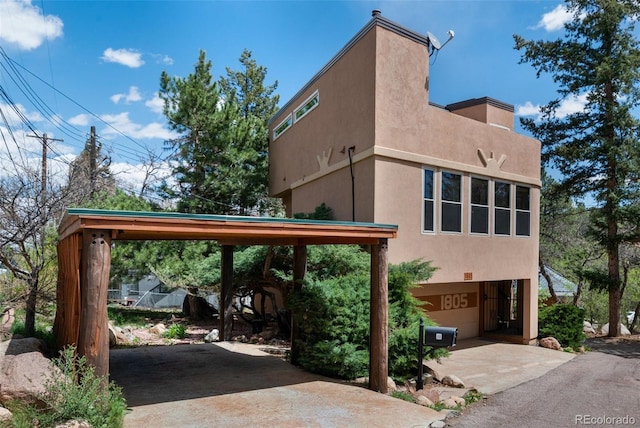 1805 Cheyenne Blvd, Colorado Springs, CO 80906 - view of side of property featuring a garage, a carport, stucco siding, and driveway