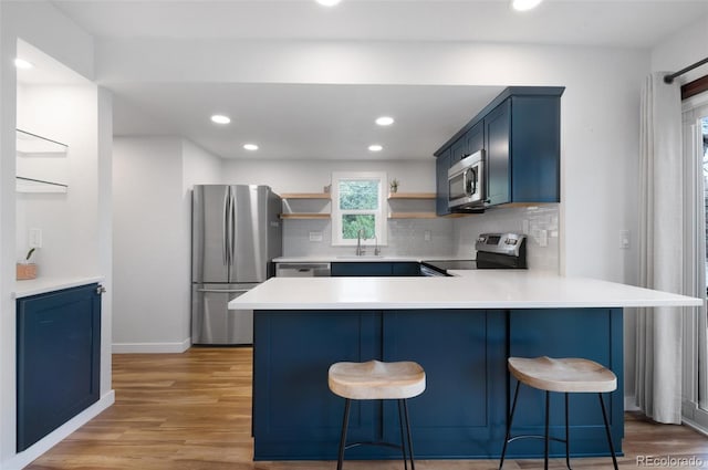 1805 Cheyenne Blvd, Colorado Springs, CO 80906 - kitchen featuring open shelves, a sink, stainless steel appliances, a peninsula, and blue cabinets