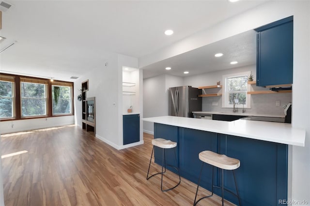 1805 Cheyenne Blvd, Colorado Springs, CO 80906 - kitchen with freestanding refrigerator, electric range, blue cabinets, a sink, and light wood-style flooring