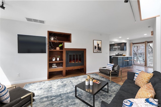 1805 Cheyenne Blvd, Colorado Springs, CO 80906 - living room featuring visible vents, wood finished floors, baseboards, a glass covered fireplace, and recessed lighting