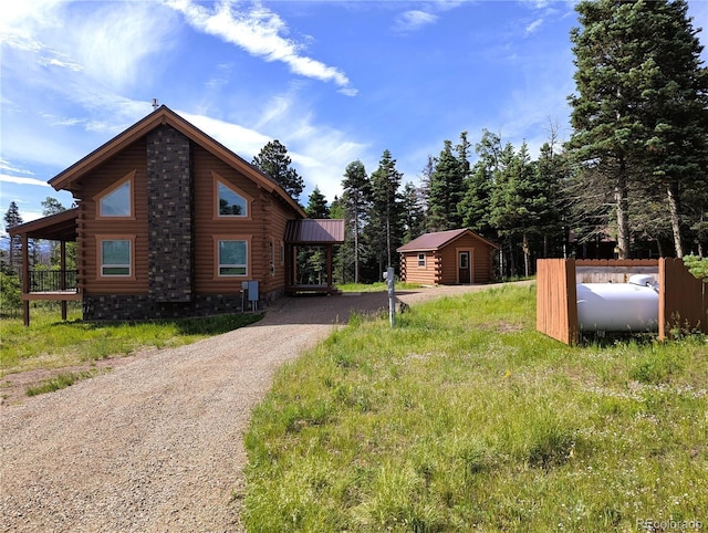 1857 Sturm Ln, Fort Garland, CO 81133 - view of side of property with log exterior, driveway, and an outbuilding