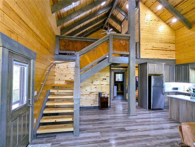 1857 Sturm Ln, Fort Garland, CO 81133 - unfurnished living room with wooden walls, high vaulted ceiling, stairway, a wood ceiling with exposed beams, and wood finished floors