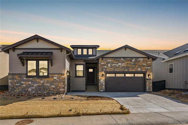 view of front facade featuring an attached garage, stone siding, and driveway