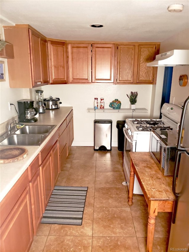 kitchen featuring light tile patterned floors, ventilation hood, sink, and gas range