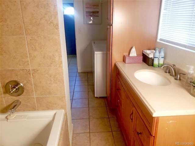 bathroom featuring a bath, tile patterned floors, vanity, and washer / dryer