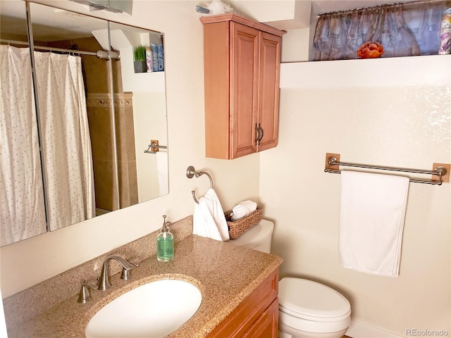 bathroom with walk in shower, vanity, and toilet