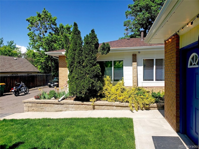 entrance to property featuring a patio and a lawn