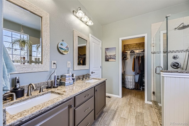 bathroom featuring vanity, wood-type flooring, and walk in shower