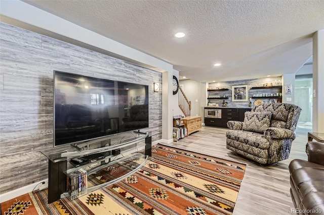 living room featuring wood-type flooring and a textured ceiling