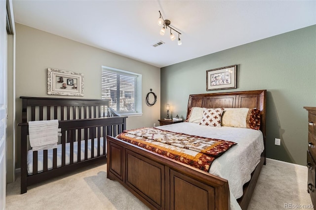 carpeted bedroom with rail lighting