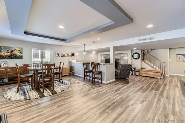 dining space with a tray ceiling and wood-type flooring